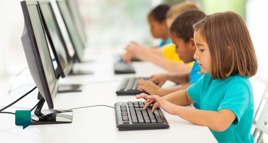 Foto de crianças no computador estudando. 